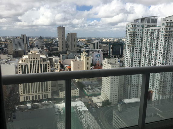 Panoramic cityscape view of high-rise buildings and urban skyline from a balcony.