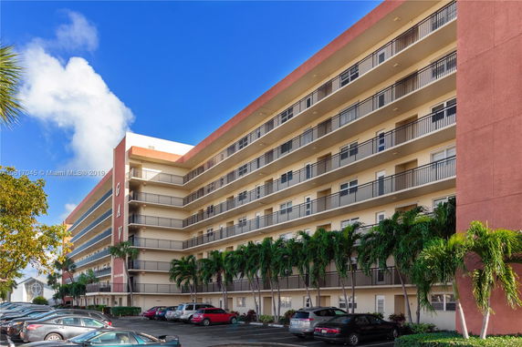 Front view of a multi-story apartment building with balconies.