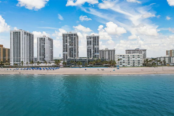 Beachfront view of multiple high-rise residential buildings.