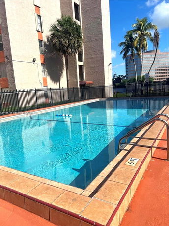 Outdoor swimming pool adjacent to a multi-story building.