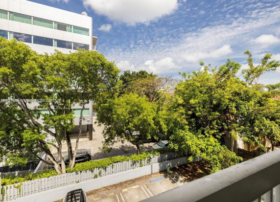 View of surrounding areas with a multi-story building and trees.