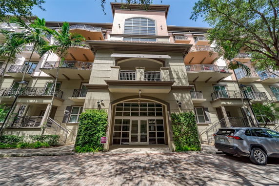 Front view of a multi-story residential building with balconies.
