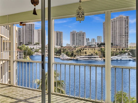 View from a balcony showing high-rise buildings, a waterway, and yachts.