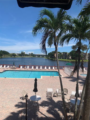 View of outdoor swimming pool area with lake in the background.