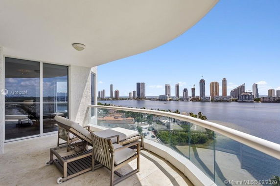 Panoramic balcony view overlooking a body of water and cityscape.