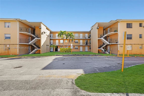 Front view of a three-story apartment building with external staircases.