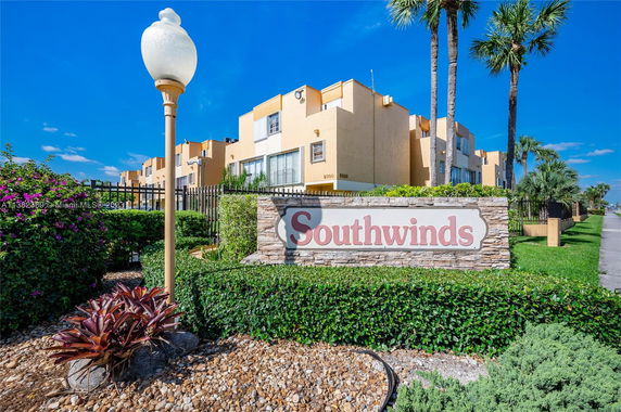 Front view of a multi-story residential building labeled 'Southwinds' with a surrounding fence.