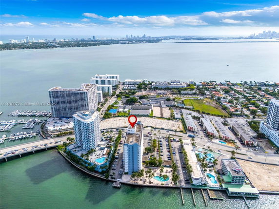 Panoramic view of a coastal area with high-rise buildings and a marina.