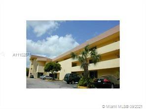 Front view of a multi-story building with parking spaces.