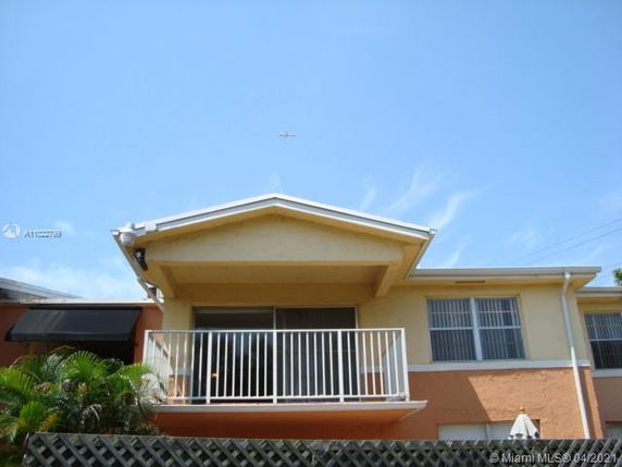 Front view of a two-story house with a balcony and white railing.