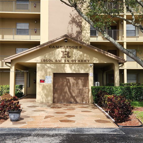 Front view of a multi-story building with a covered entrance and balconies.