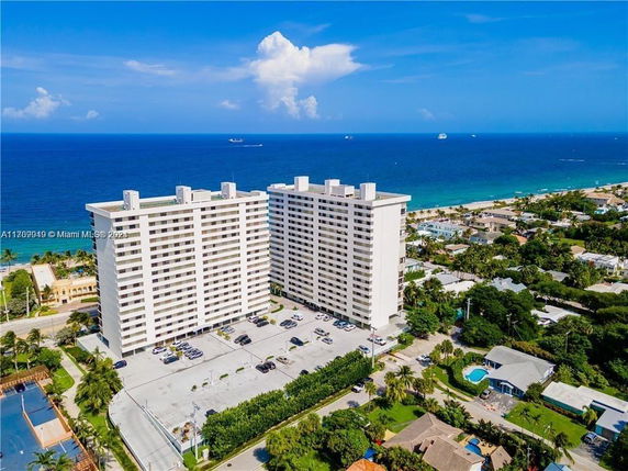 Aerial view of two tall residential buildings near the ocean.