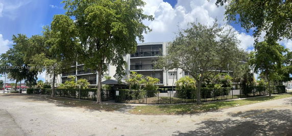 Front view of a multi-story building with a gated entrance and balconies.
