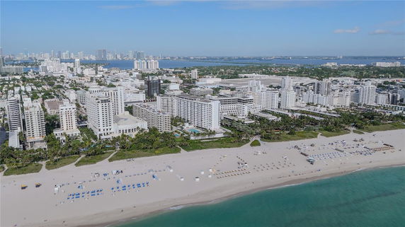 Panoramic view of a coastal city with beachfront and numerous high-rise buildings.