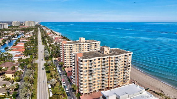 Panoramic view of beachfront apartment buildings next to a long coastal road.