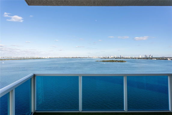Panoramic view of a city skyline across a body of water from a balcony.