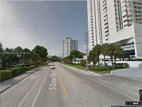 Street view with tall residential buildings lining the road.