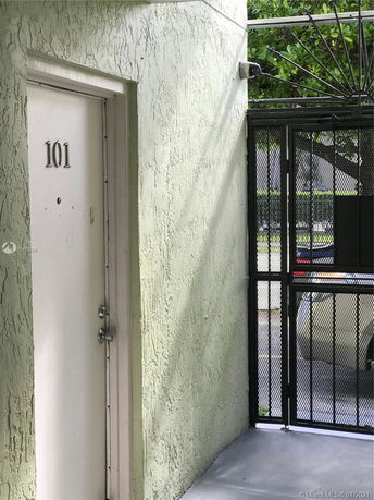Front view of a door labeled 101 next to a metal gate.