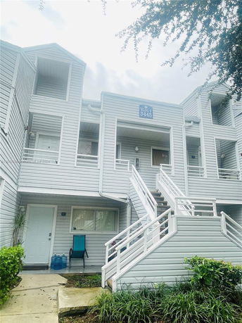 Front view of a multi-story residential building with stairs leading to entrances.
