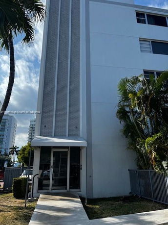 Front view of a multi-story building with vertical accent walls and an entrance canopy.