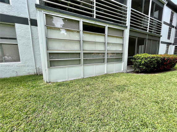 Front view of a house with enclosed balconies and sliding glass doors.