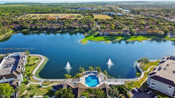 Aerial view of residential buildings near a lake with fountains.