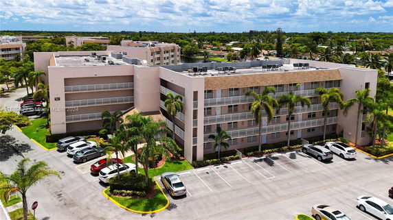 Front view of a multi-story apartment building with a parking area