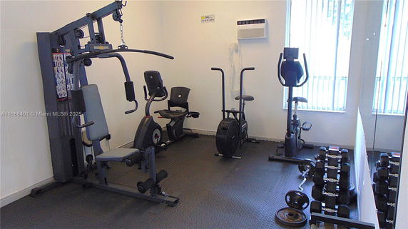 Indoor gym area with exercise machines and weights.