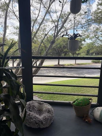 View from a balcony showing trees and a road.