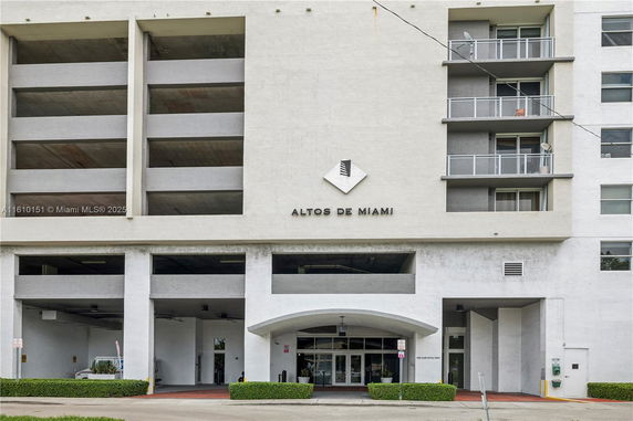 Front view of a building with visible parking areas and balconies.