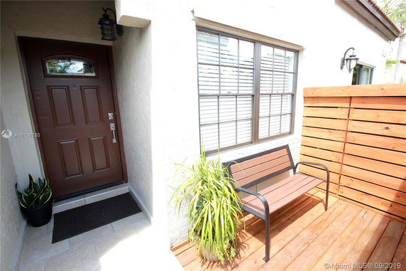 Front view of a house entrance with a wooden door and adjacent window.