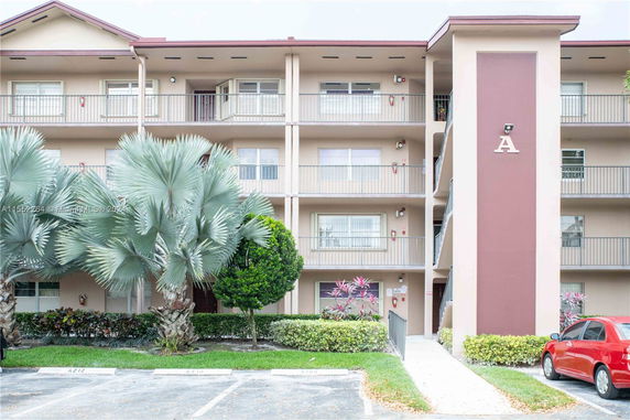 Front view of a multi-story apartment building with balconies and entrance.
