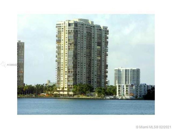 Front view of a tall apartment building by the water.