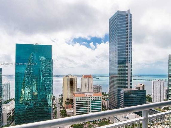 Panoramic view of high-rise buildings with a body of water in the distance.