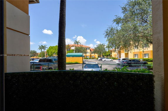 View of apartment buildings with cars parked in the parking area.