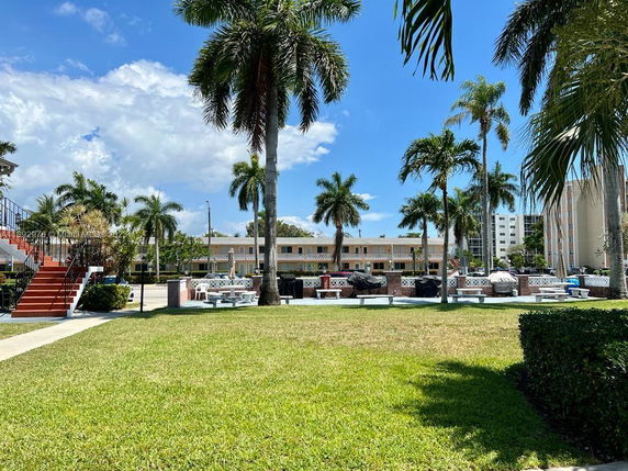 View of a residential area with palm trees and outdoor seating.