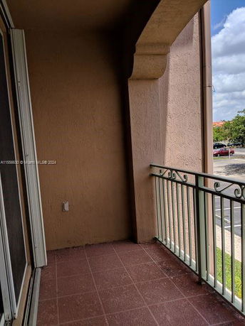 Balcony with a view of the parking area and surrounding trees.