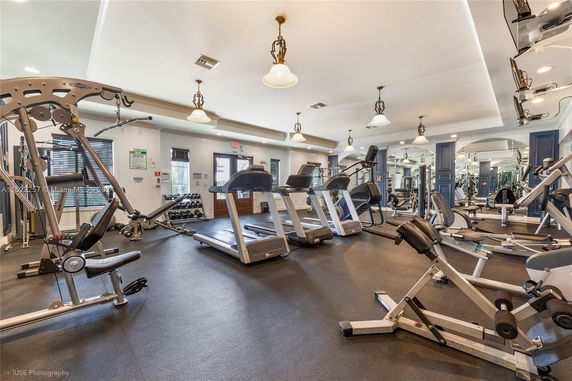 Gym area with exercise equipment including treadmills and weight machines.