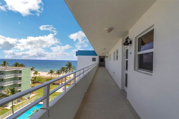 Outdoor corridor of a building overlooking the ocean.