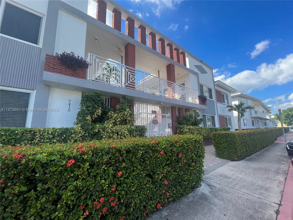 Front view of a multi-story residential building with balconies and a well-maintained facade.