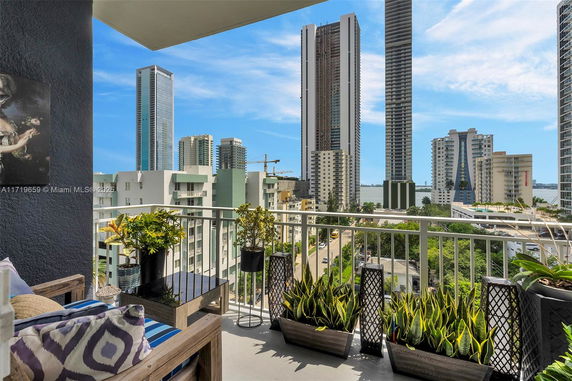 View from a balcony showing multiple high-rise buildings in an urban area.