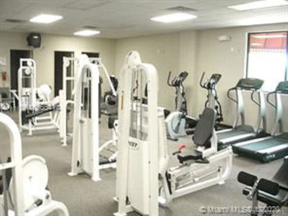 Indoor gym area with exercise equipment including treadmills and weight machines.