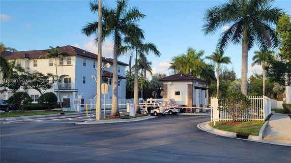 Front view of a multi-story residential building with a security gate area.