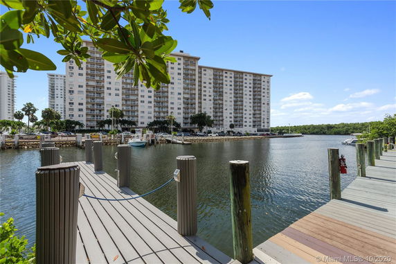 View of a waterfront area with a tall apartment building in the background.