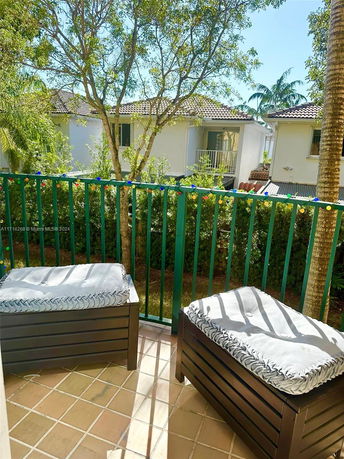 Balcony view overlooking nearby trees and neighboring houses.