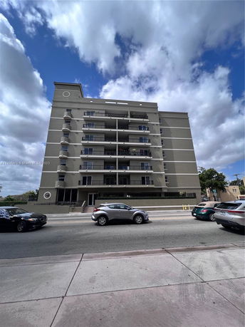 Front view of a multi-story apartment building with balconies.
