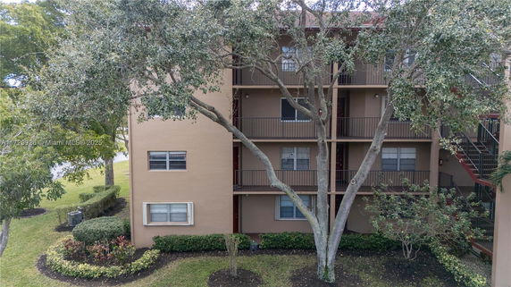 Front view of a multi-story apartment building with balconies and windows.