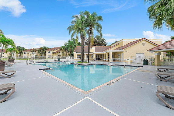 Outdoor swimming pool area with surrounding residential buildings.
