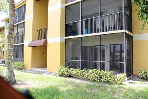 Front view of a multi-story building with screened balconies.