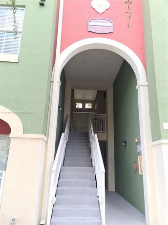 Entrance view of a multi-story building with colored walls and stairs.